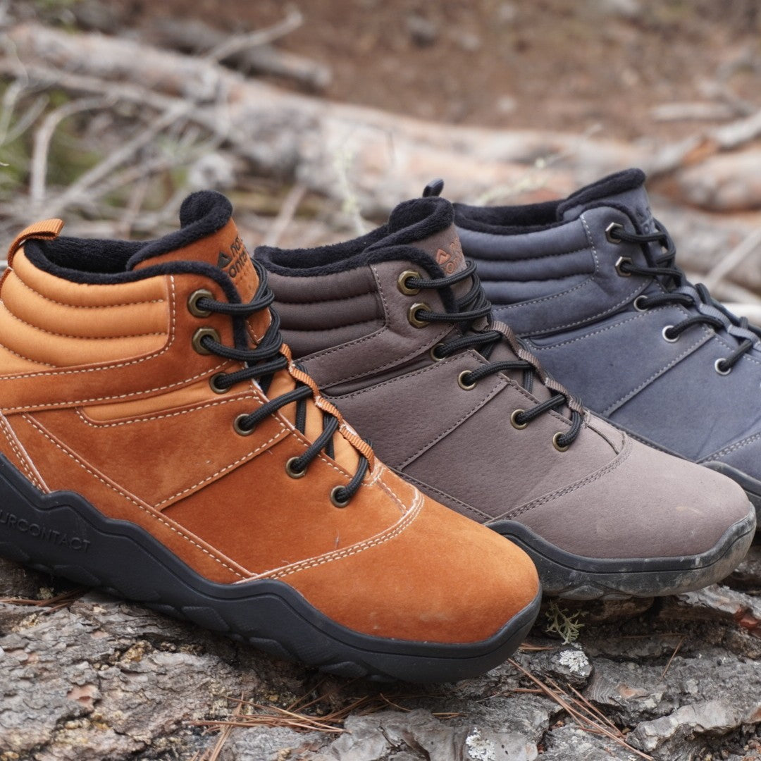 three barefoot winter shoes gold, dark brown and grey next to each other in a autumn forest