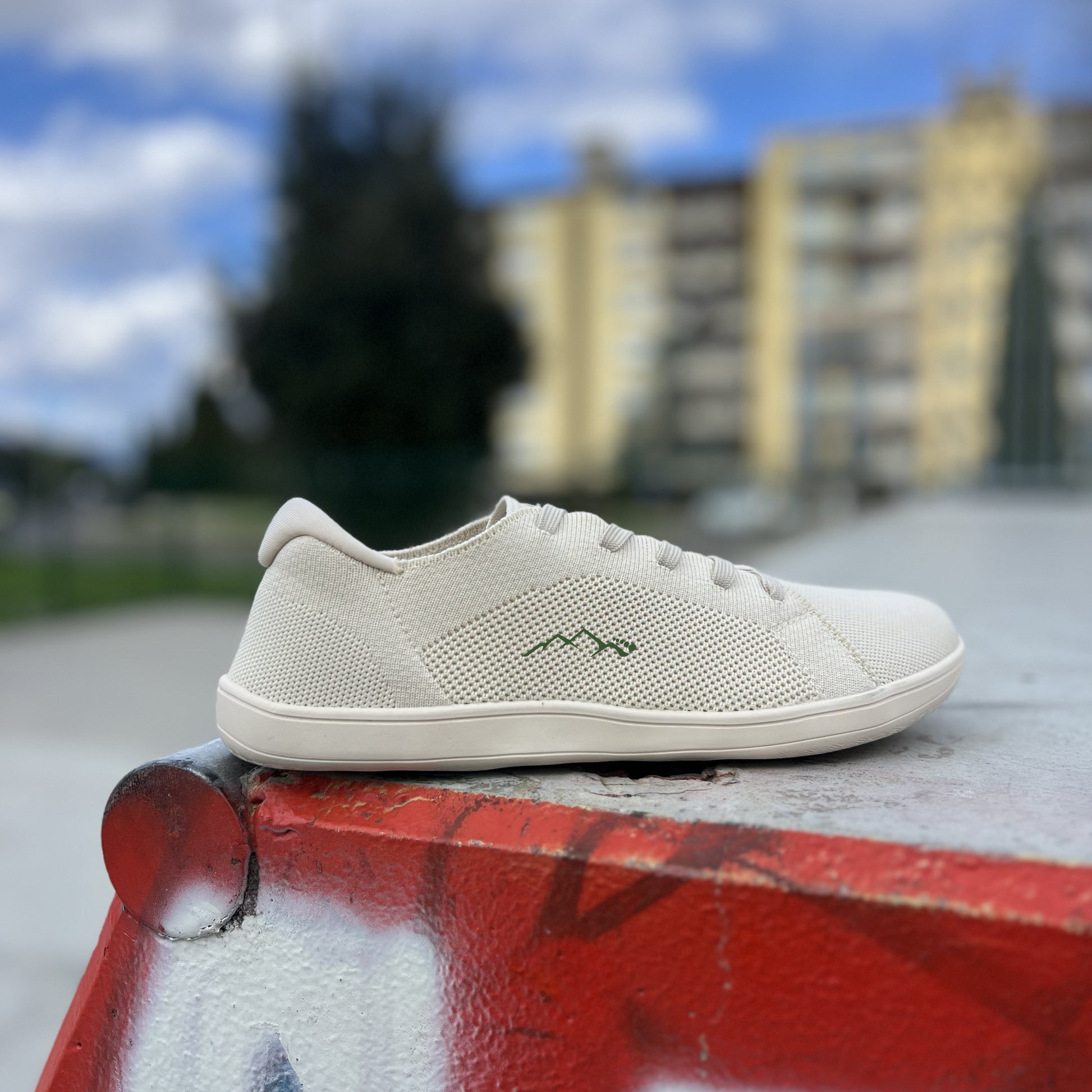 side view of beige barefoot shoes on a skate park with detail of the breathable texture