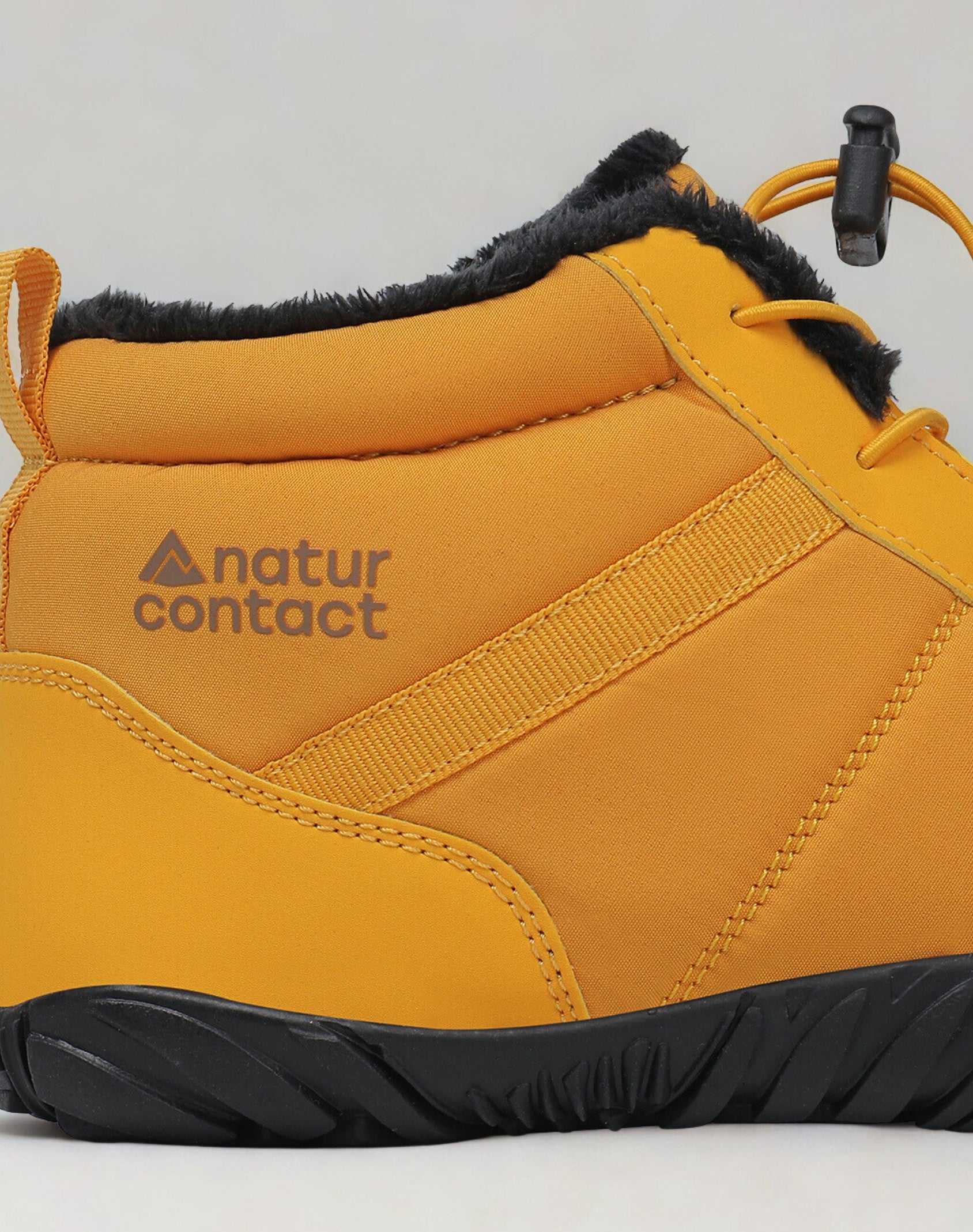 Yellow winter boot with black sole and 'natur contact' logo on a light gray background