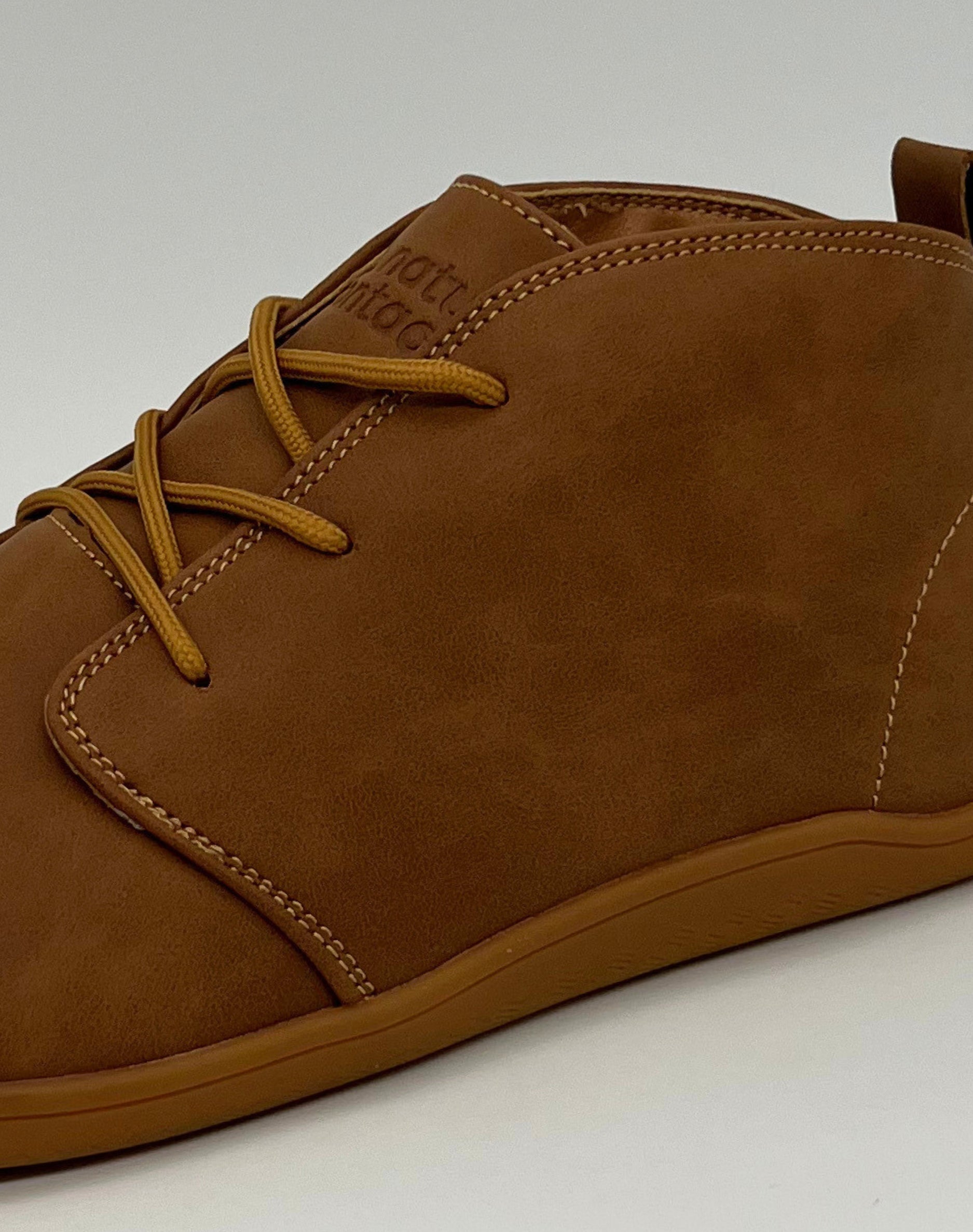 Brown leather shoe with laces on a white background