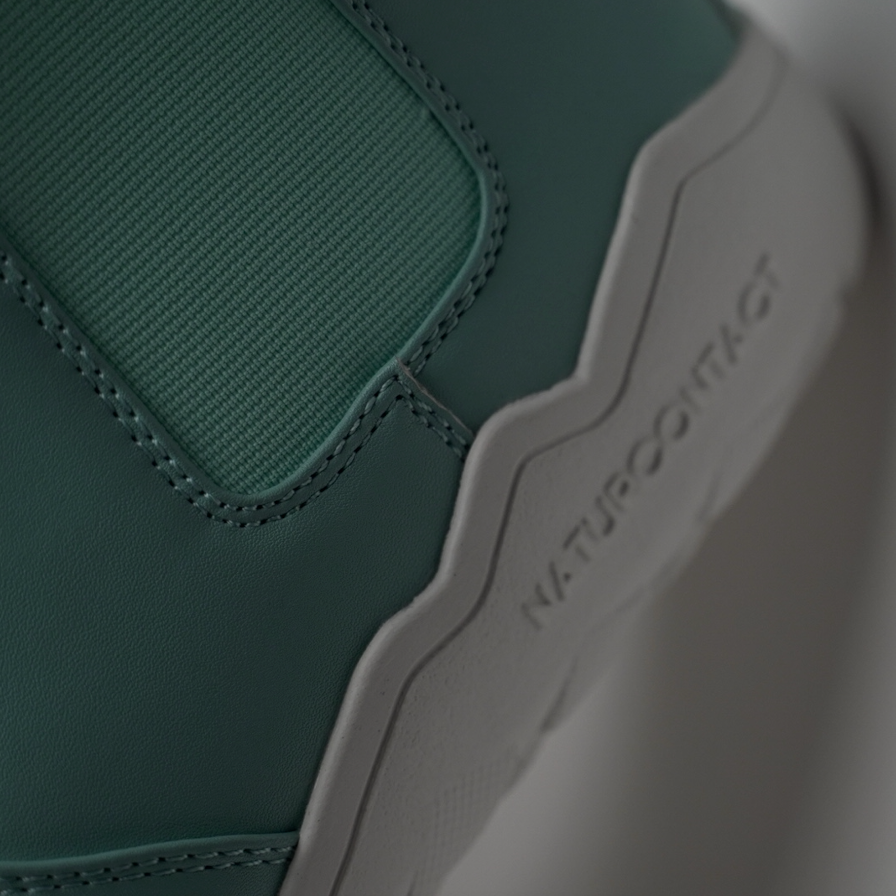 detail of closure and stitching of light blue barefoot chelsea boots