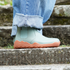 side view of barefoot chelsea boots on stairs with orange sole