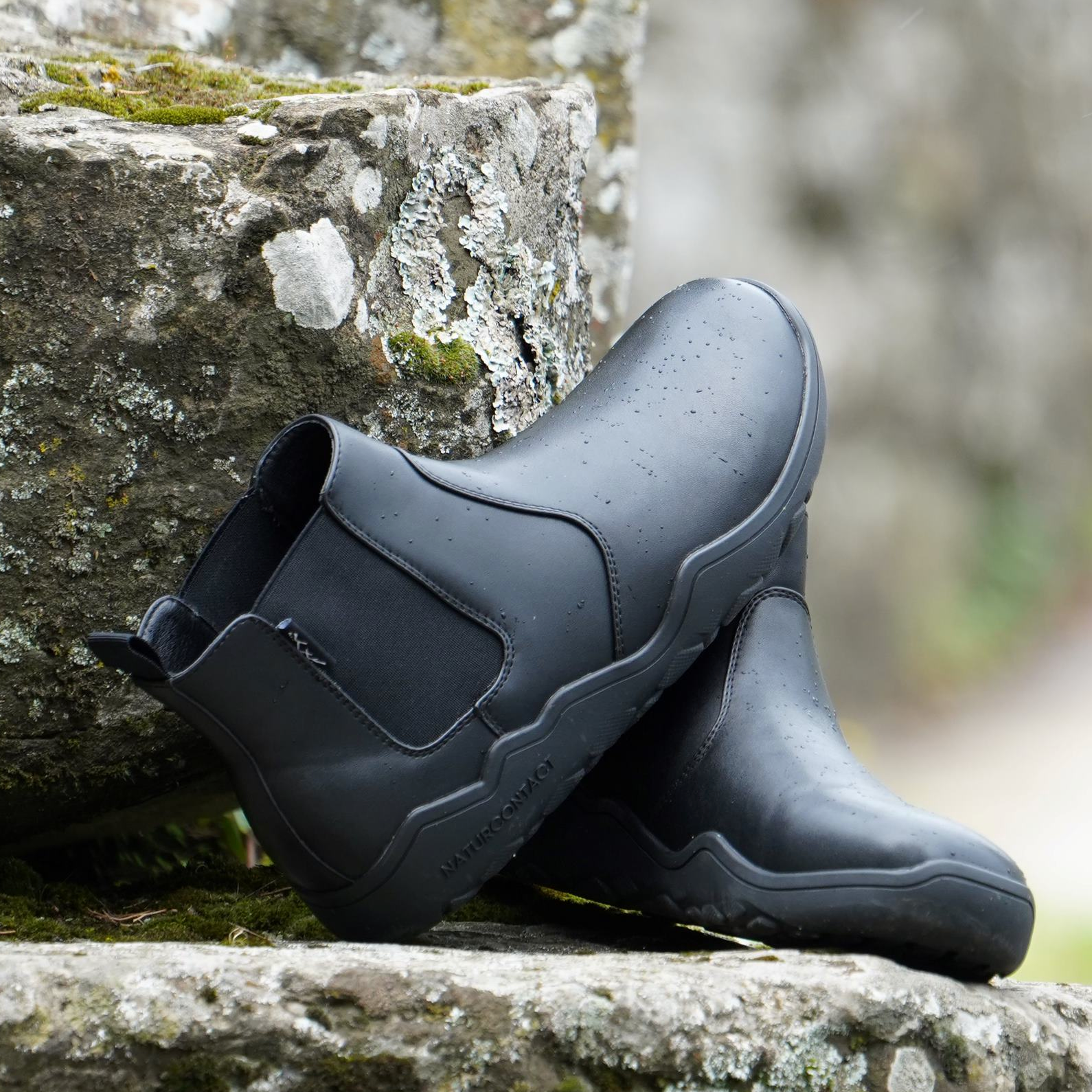 black chelsea barefoot boots on a rock