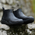black wet barefoot chelsea boots on a rock