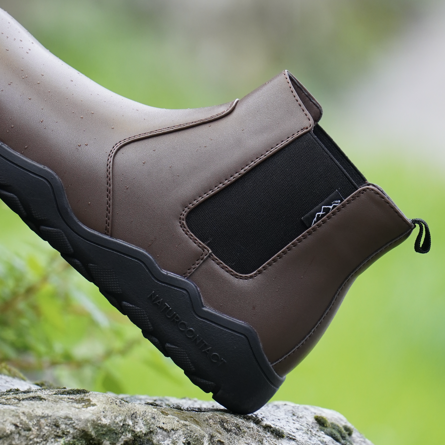 side view of brown chelsea barefoot boots on a rock