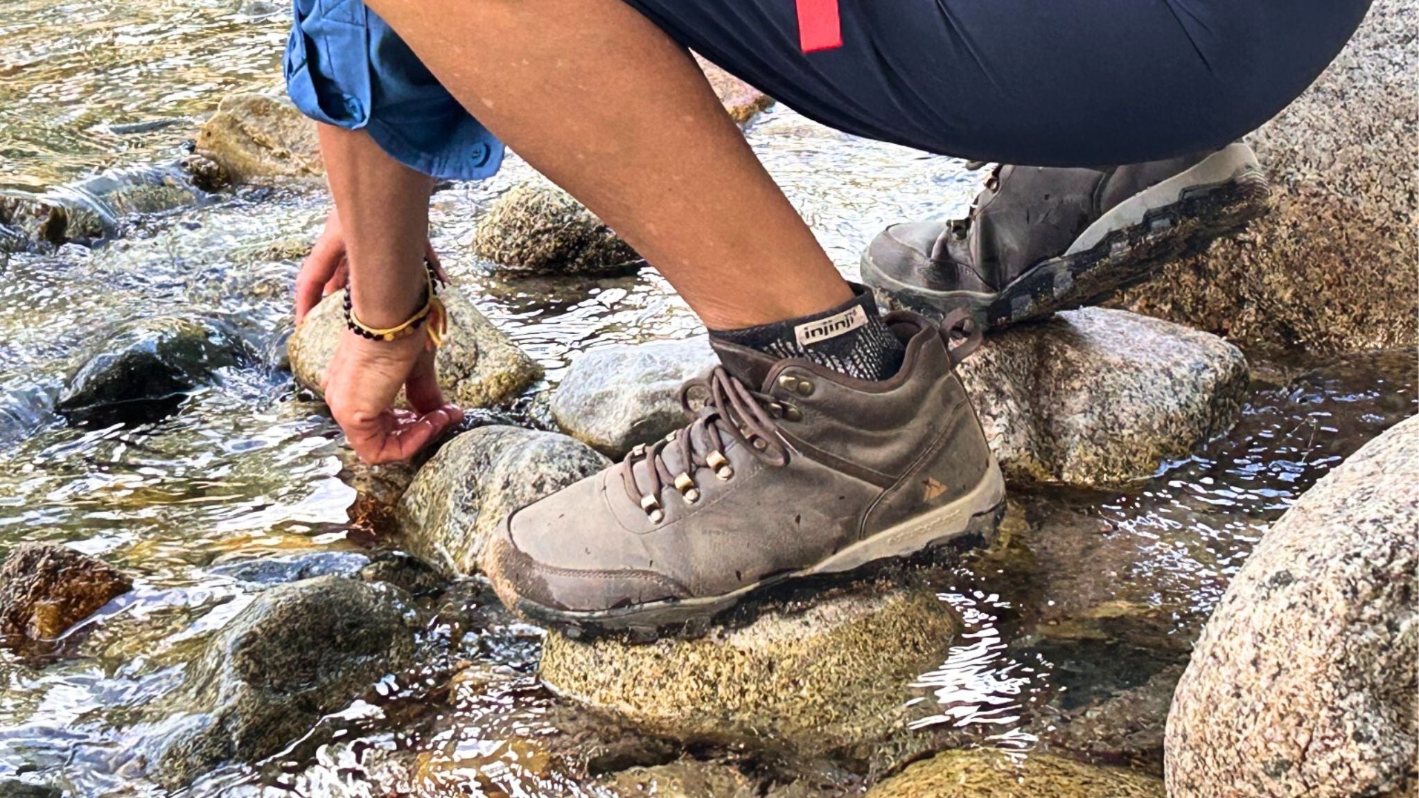 Naturcontact barefoot hiking boots testing grip and waterproof performance on river rocks.