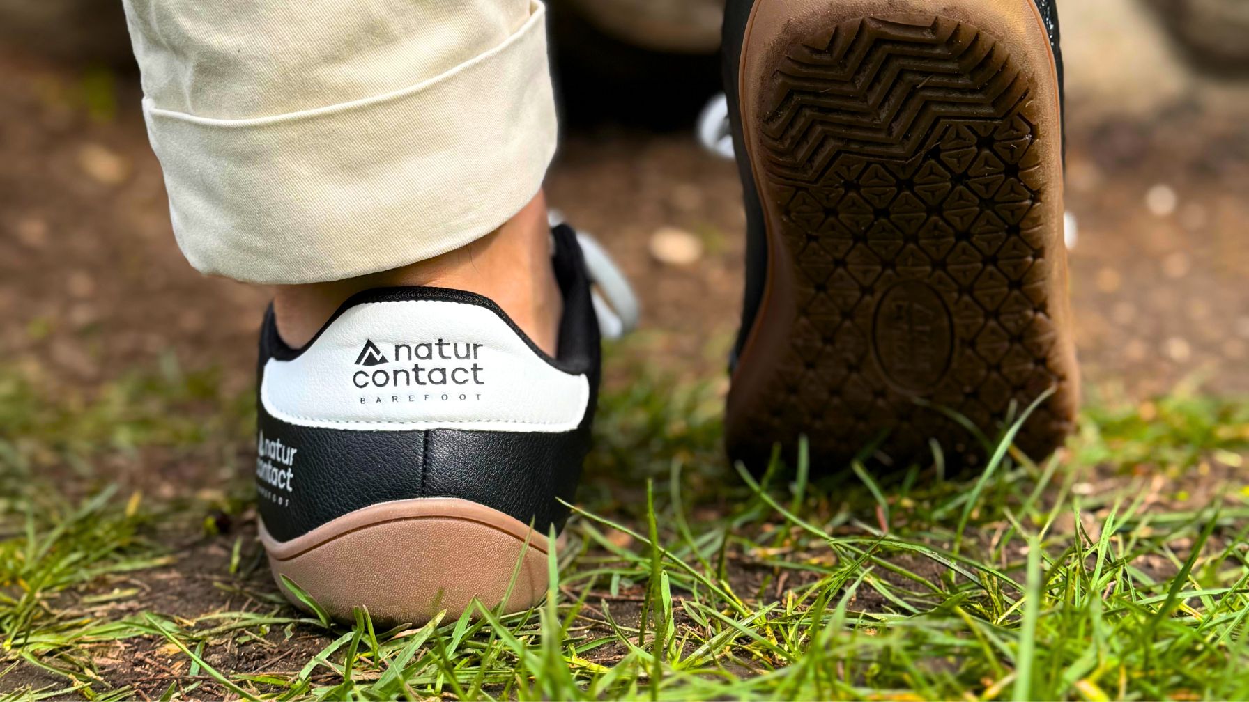 Naturcontact barefoot shoes walking on natural ground with the sole visible to illustrate grounding and outdoor connection