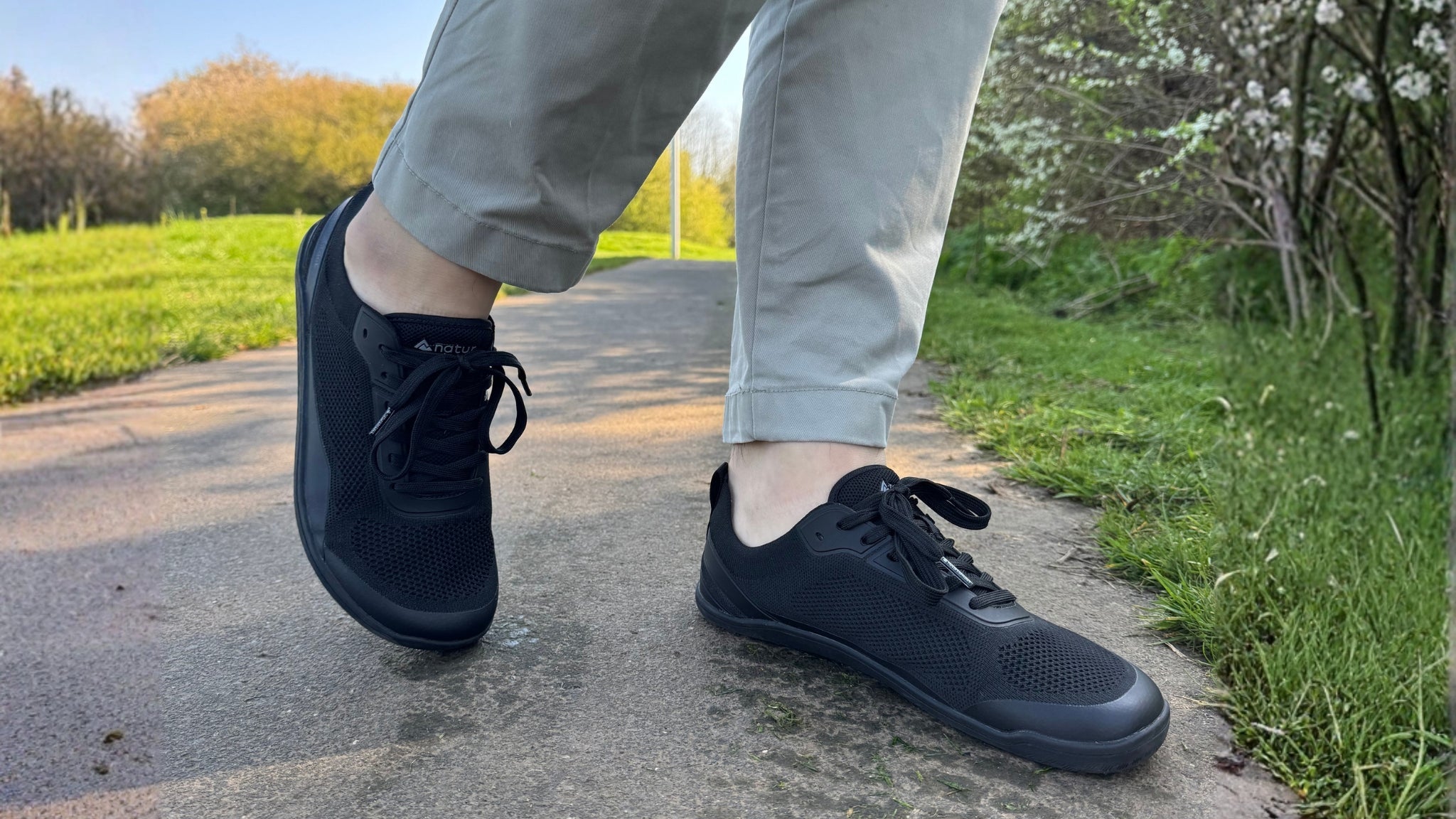 Black barefoot shoes with thick soles designed for long walks and daily commuting on asphalt.
