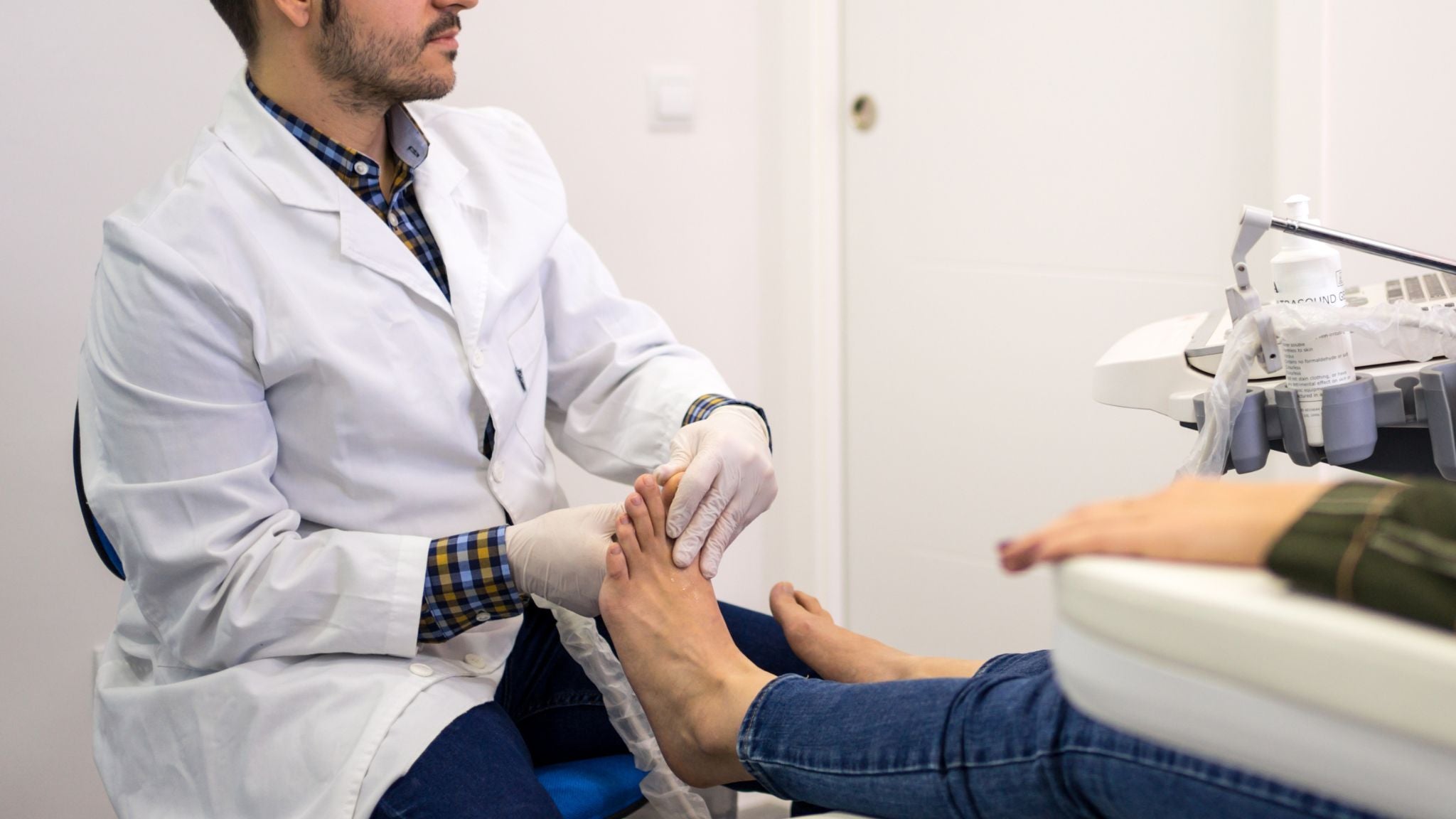 Podiatrist assessing a patient’s foot and explaining how Naturcontact zero drop barefoot shoes support natural posture and movement.