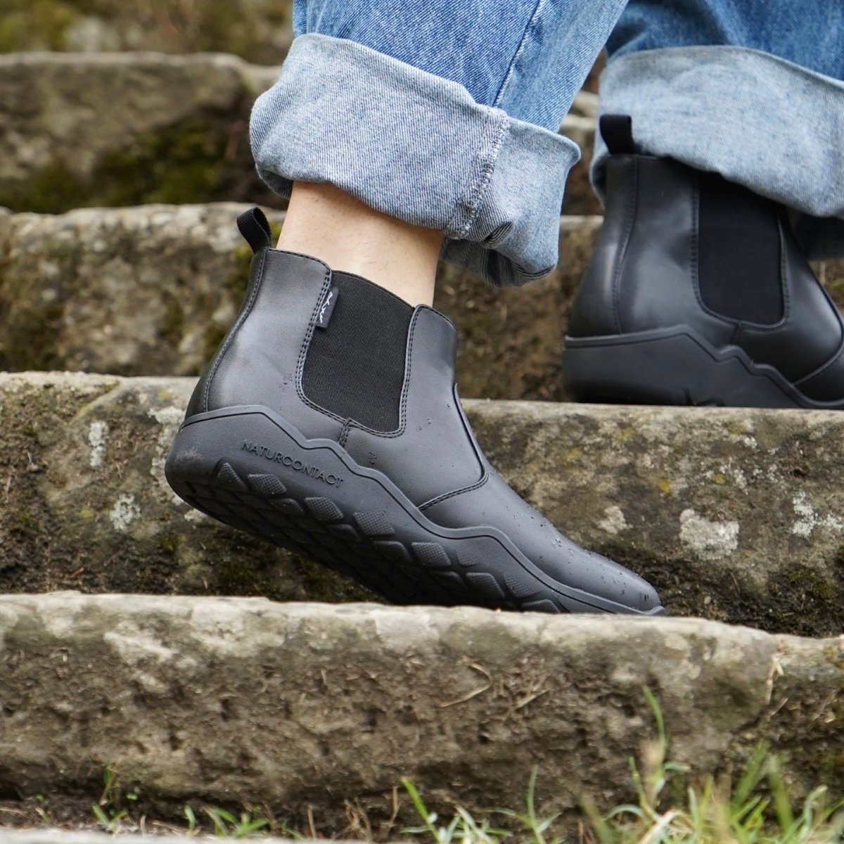 black barefoot boots with jeans on old stone stairs