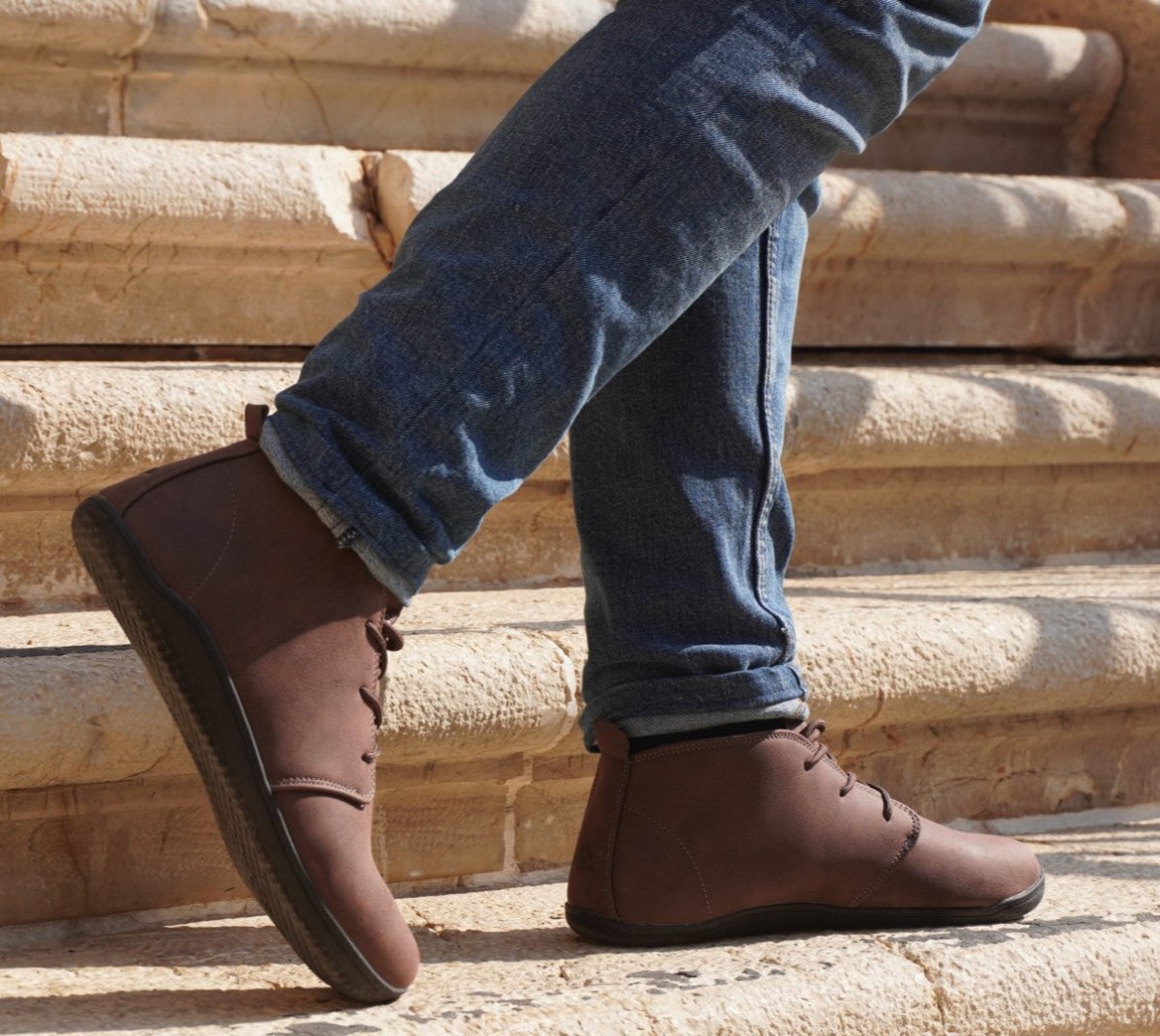 brown smart barefoot shoes for men on pavement with blue jeans