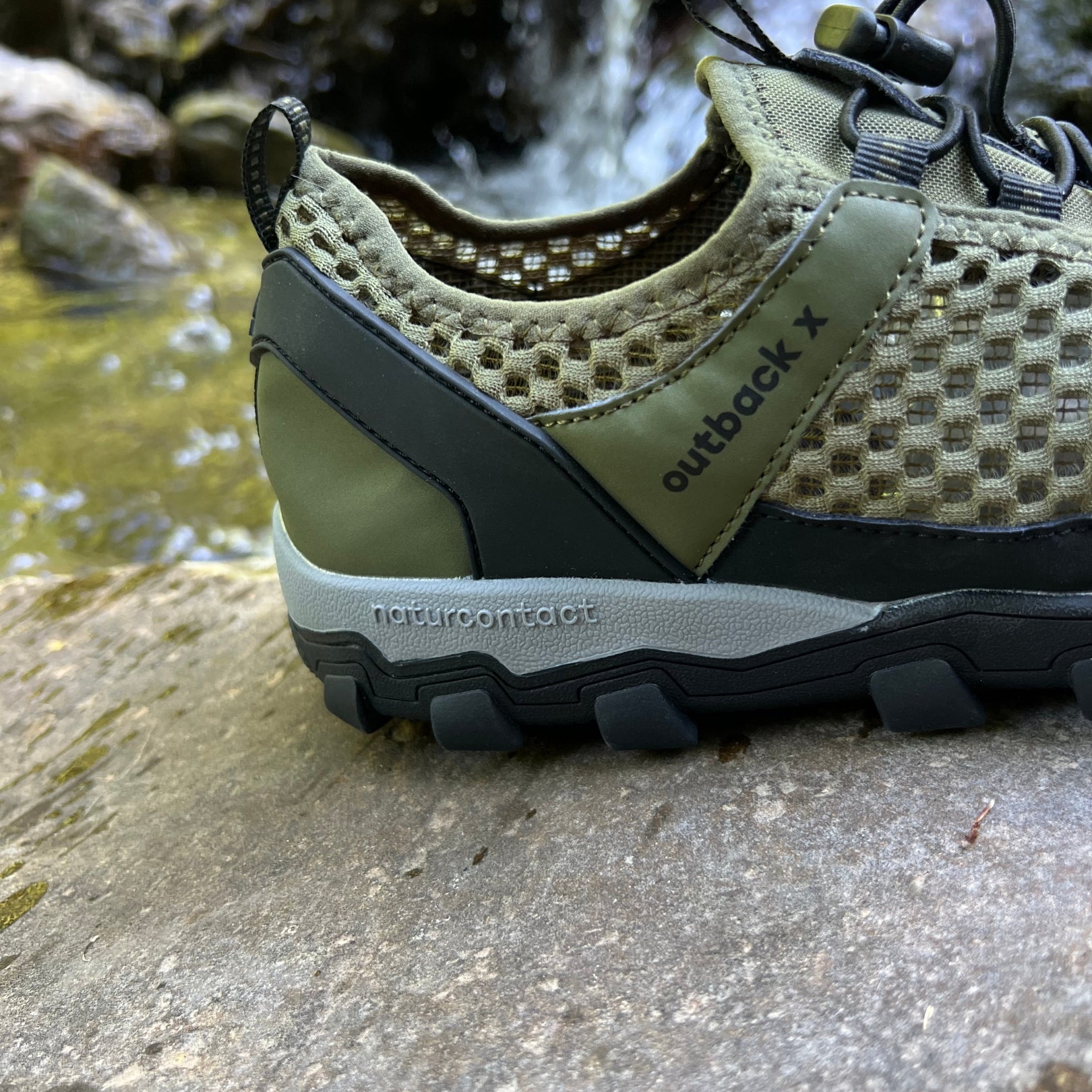 Military green hiking barefoot shoe on natural rock landscape, back detail