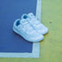 Pair of White Daily Barefoot shoes in an outdoor sports park