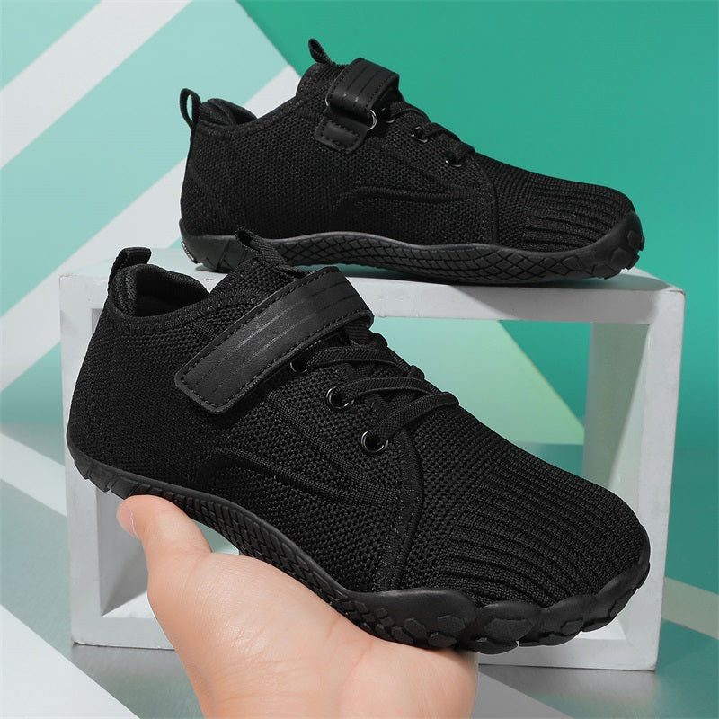 Black athletic barefoot shoes for kids on a light blue geometric background