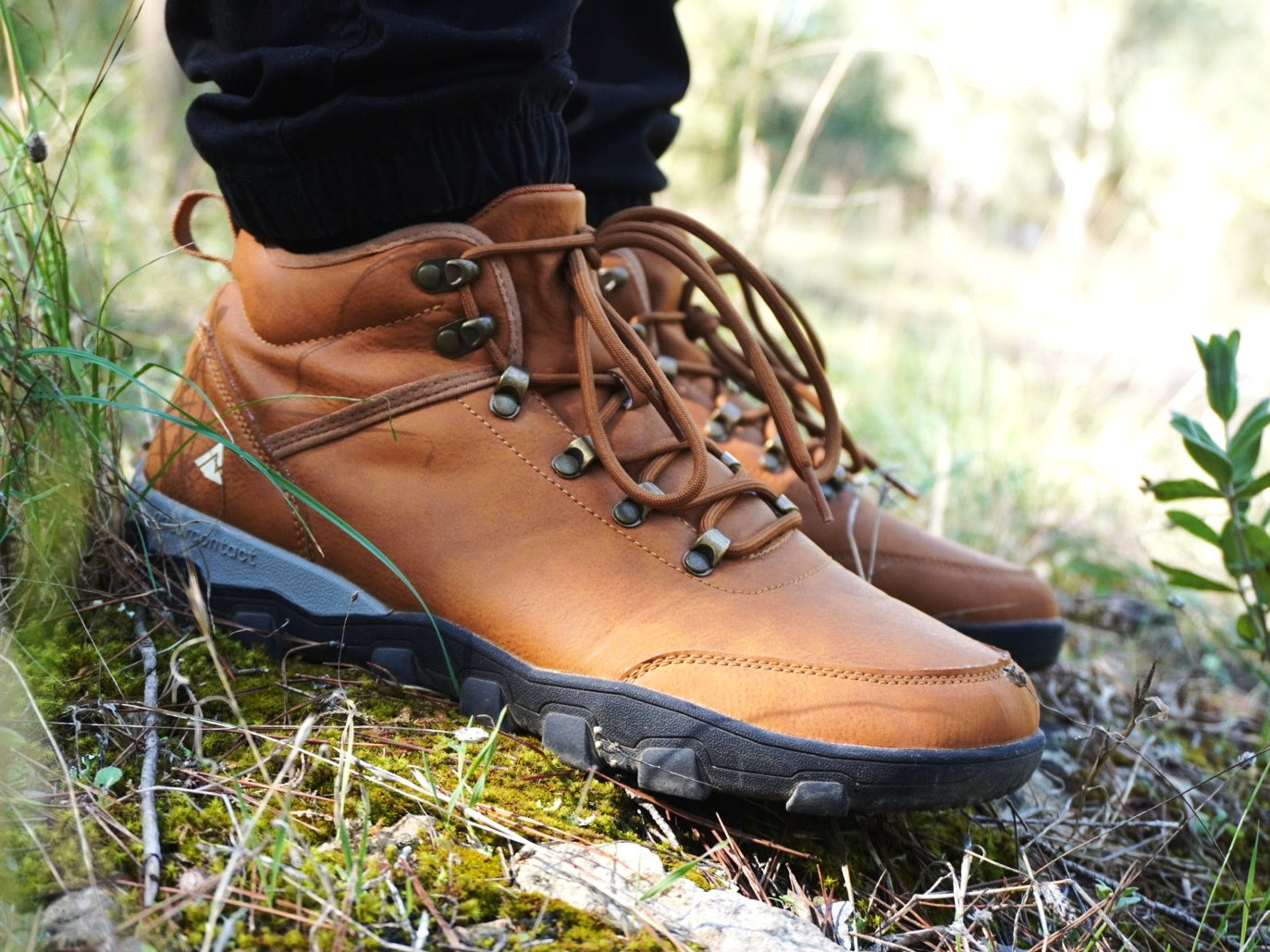 Brown hiking boots with black soles on a natural background