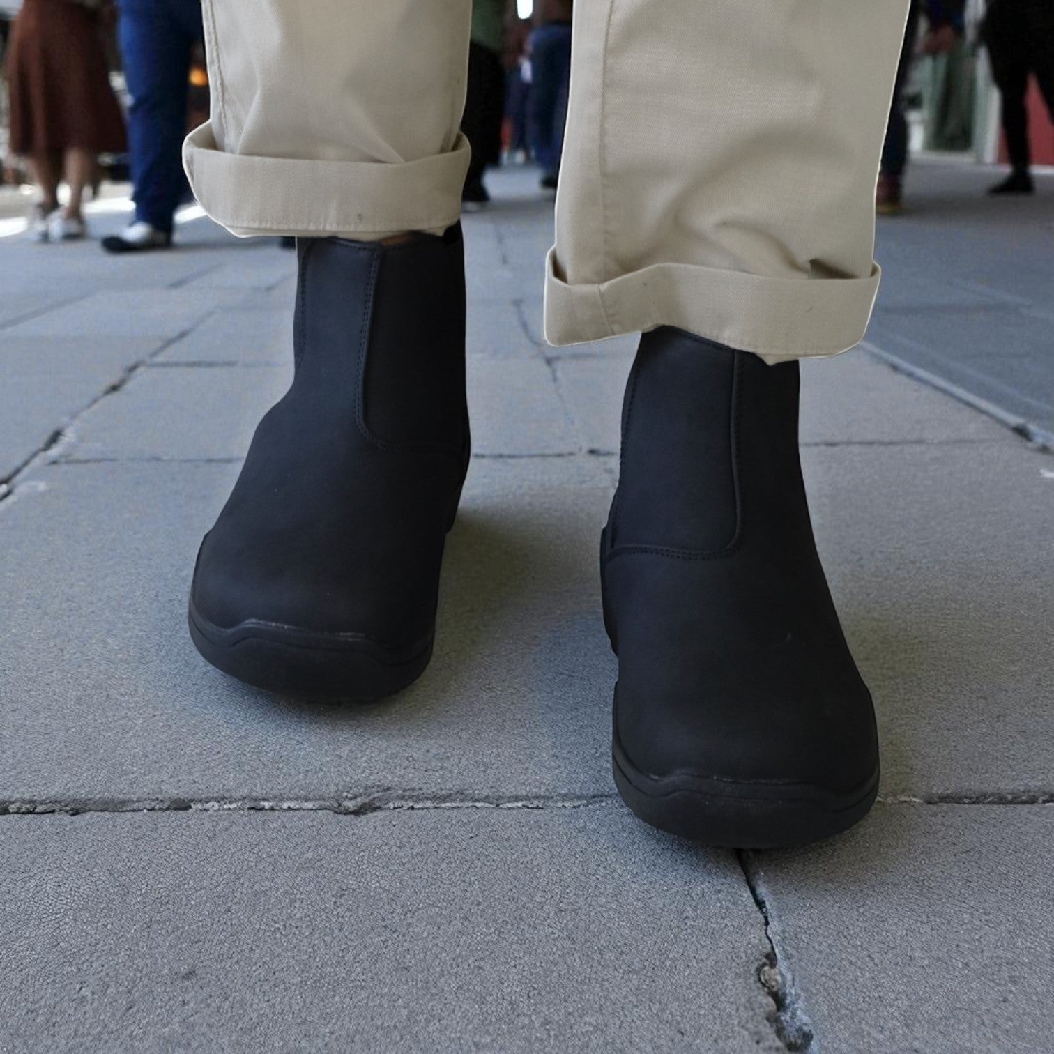 Black barefoot boots worn on a sidewalk with a blurred background