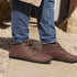 Brown smart barefoot shoes  shoes worn with blue jeans on a stone surface