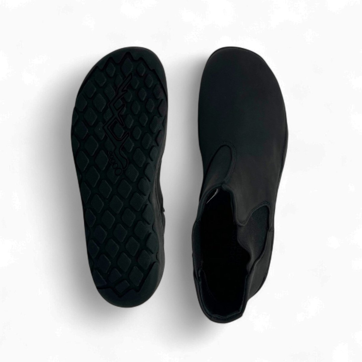 Black slip-on shoes with textured sole on a white background