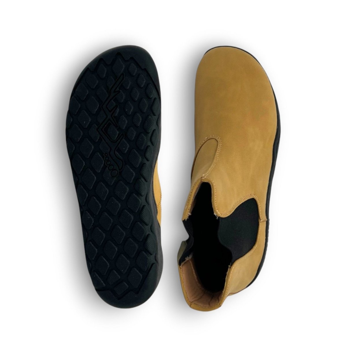 Tan shoe with black sole on a white background