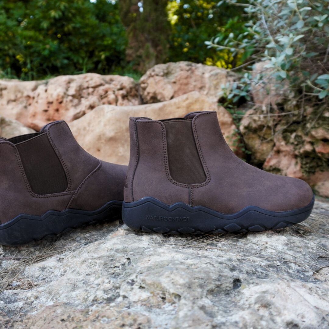 Pair of brown slip-on shoes on a rock with a natural background