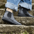 side view of Black barefoot chelsea boots on stairs