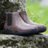 side view of Coffee minimalistic barefoot chelsea boots on a rock