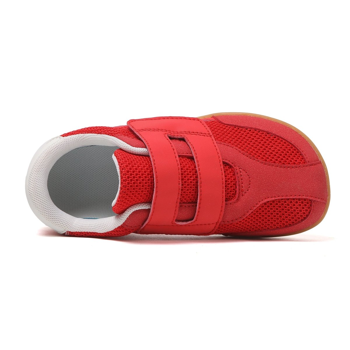 Red barefoot children's shoe with velcro straps on a white background
