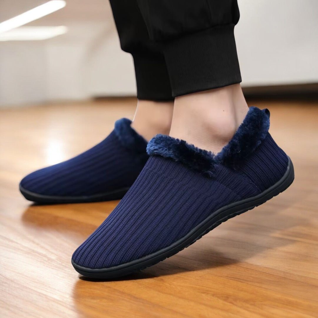 Navy blue Kozy Contact 2.0 barefoot slippers with fuzzy trim worn indoors 