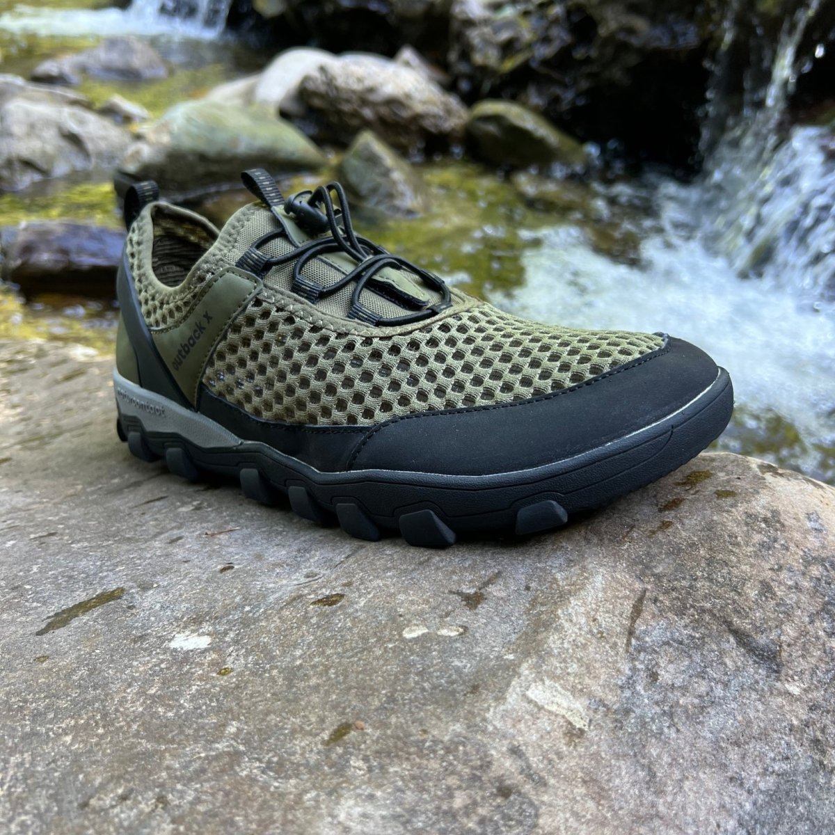 Military green hiking barefoot shoe on natural rock landscape