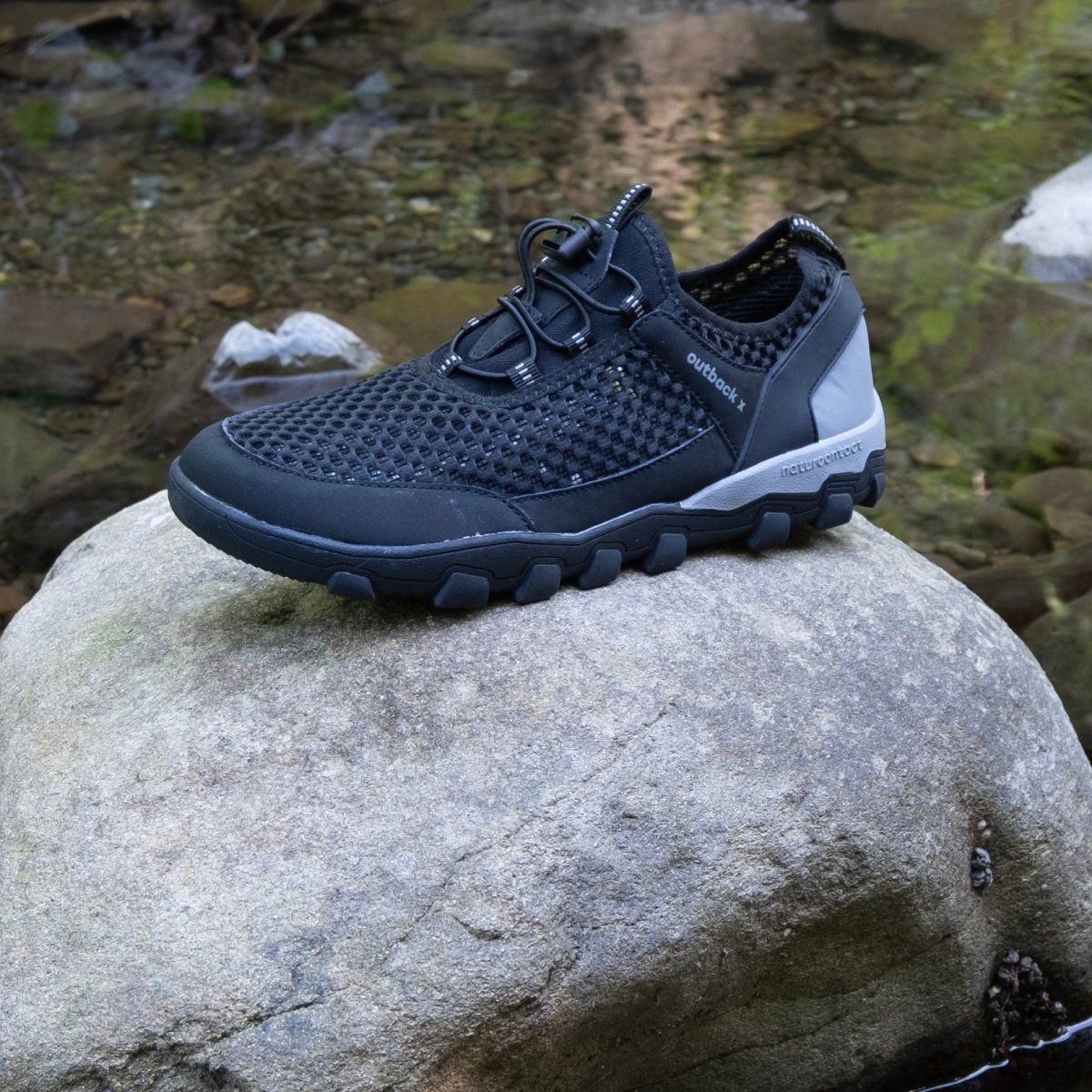 Black hiking barefoot shoe on natural rock landscape