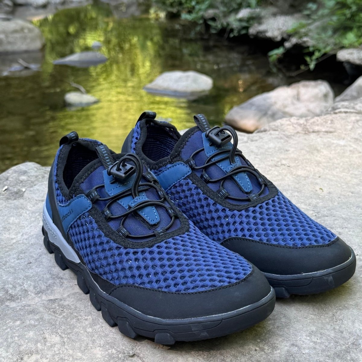 Blue hiking barefoot shoe on natural rock landscape