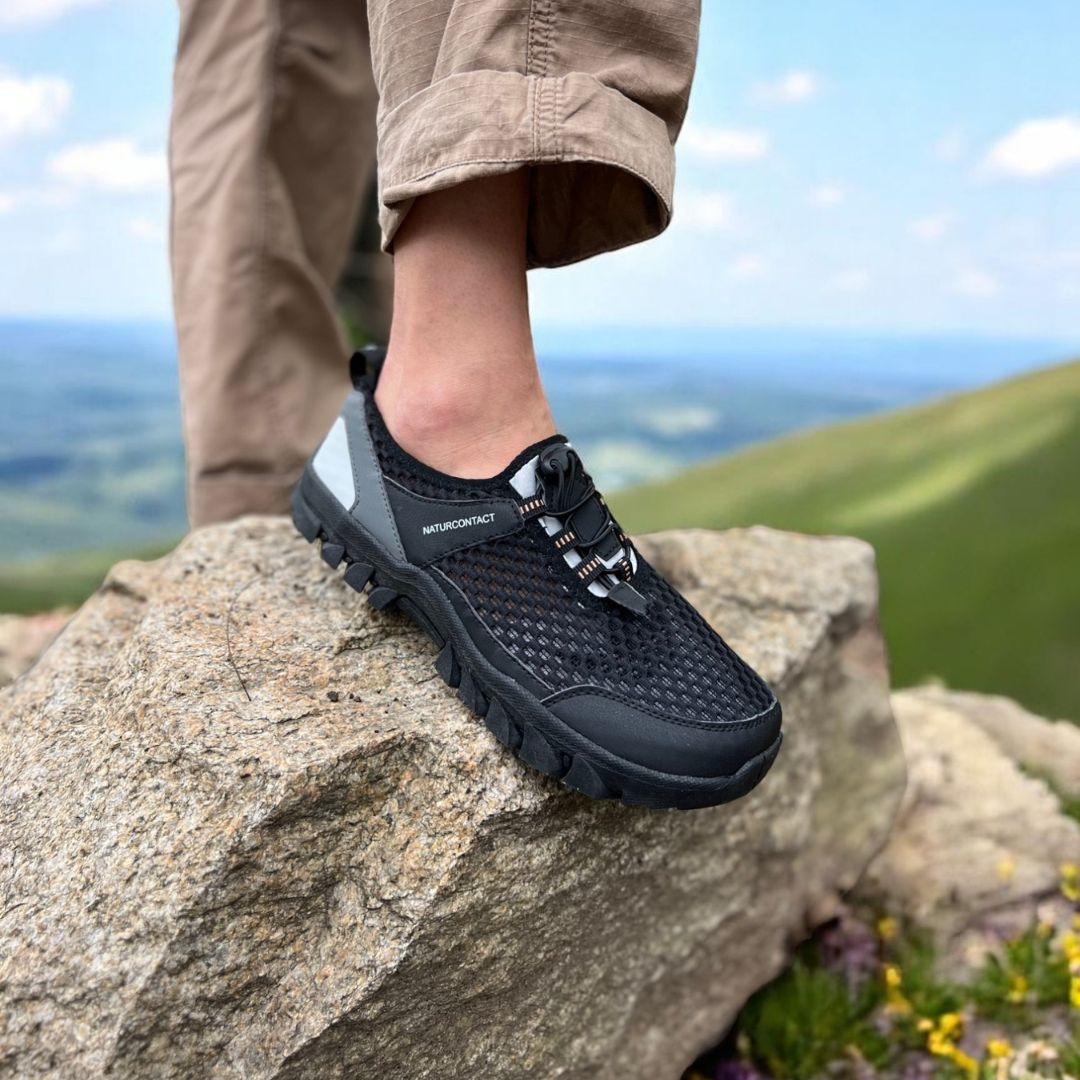 black trekking shoes barefoot minimalistic hiking worn on a rock