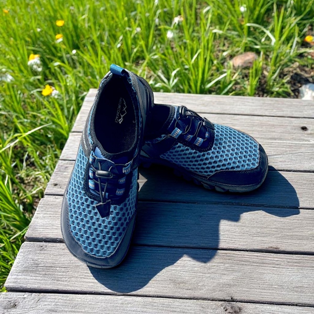 pair of blue wide toe box hiking barefoot trekking shoes on a table