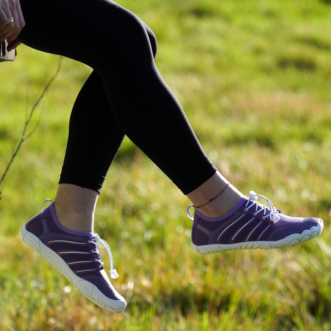 side view purple worn barefoot shoes on grass