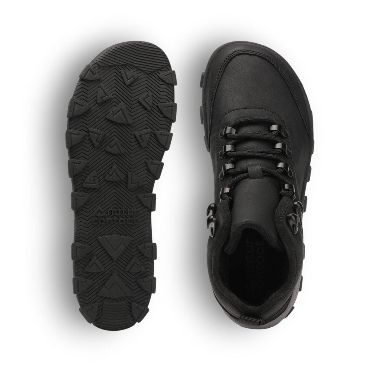 Black hiking boots with tread pattern on sole on a white background