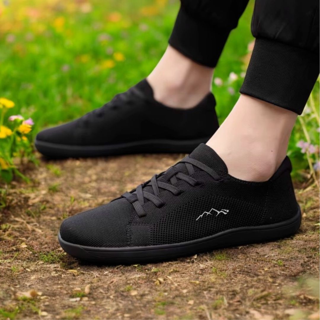 side view of black minimalist summer barefoot shoes on the grass