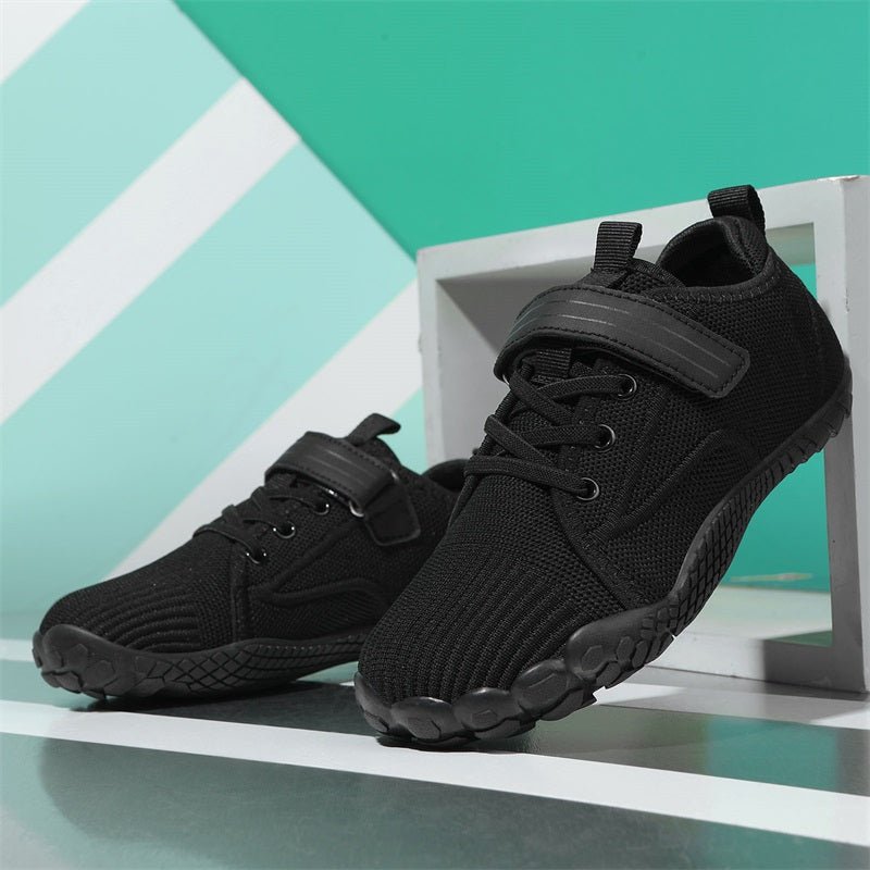 Black athletic barefoot shoes for kids on a light blue geometric background