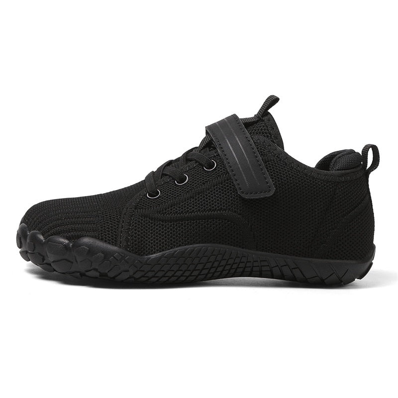 Black athletic barefoot shoe for kids with a sole pattern on a white background