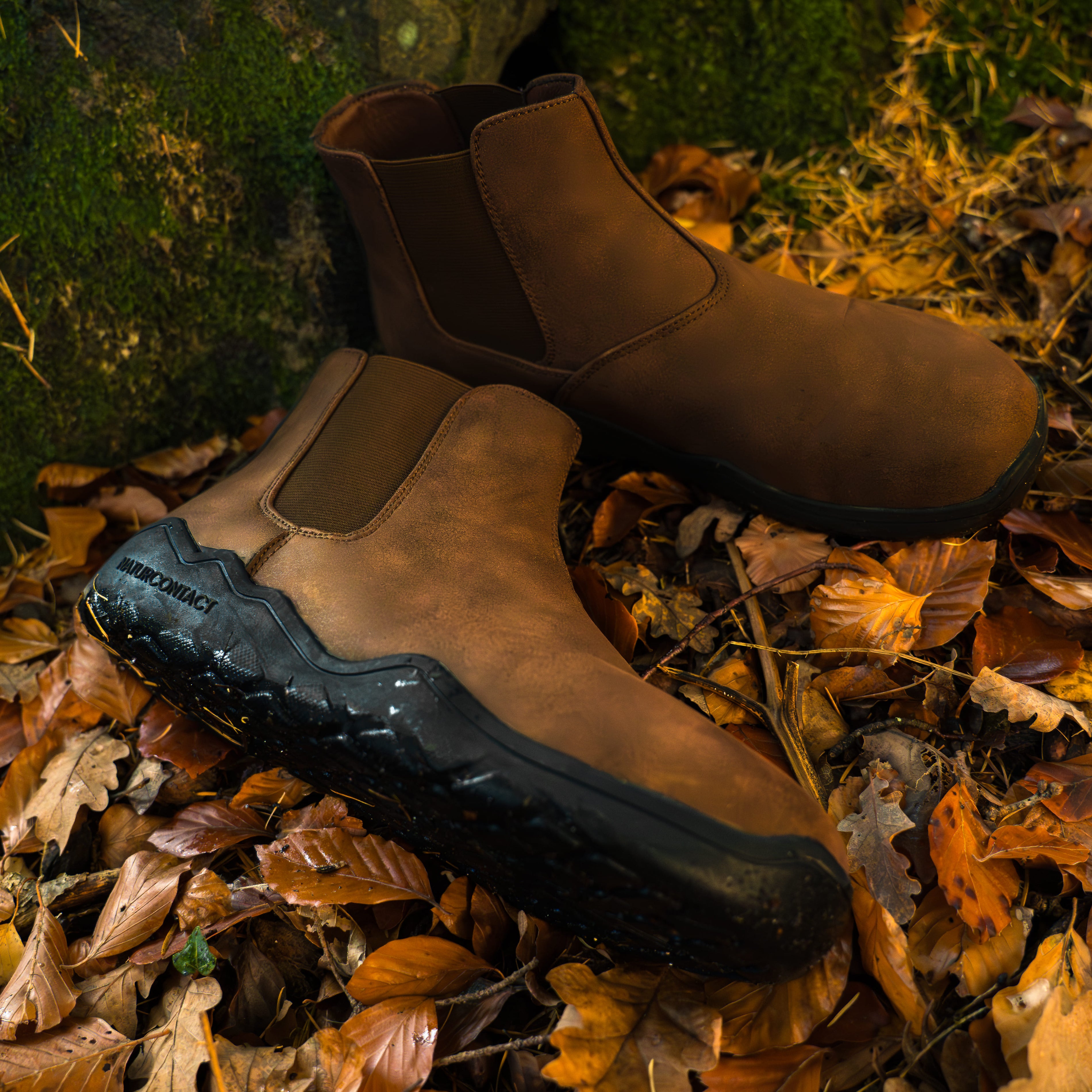 Brown chelsea barefoot boots on a bed of autumn leaves