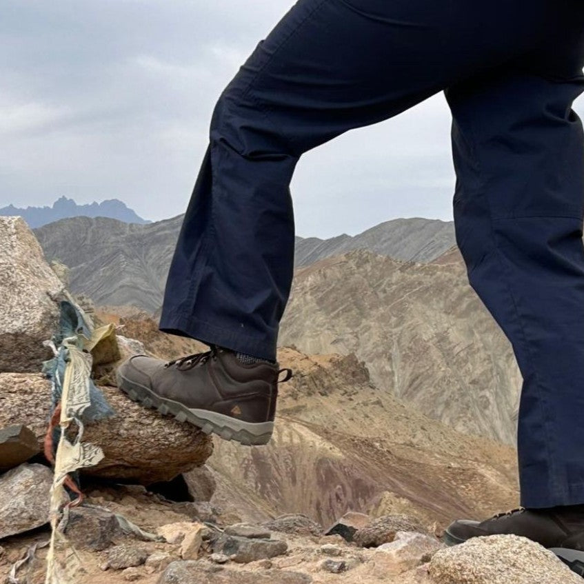 Person wearing hiking boots and pants on a mountainous landscape