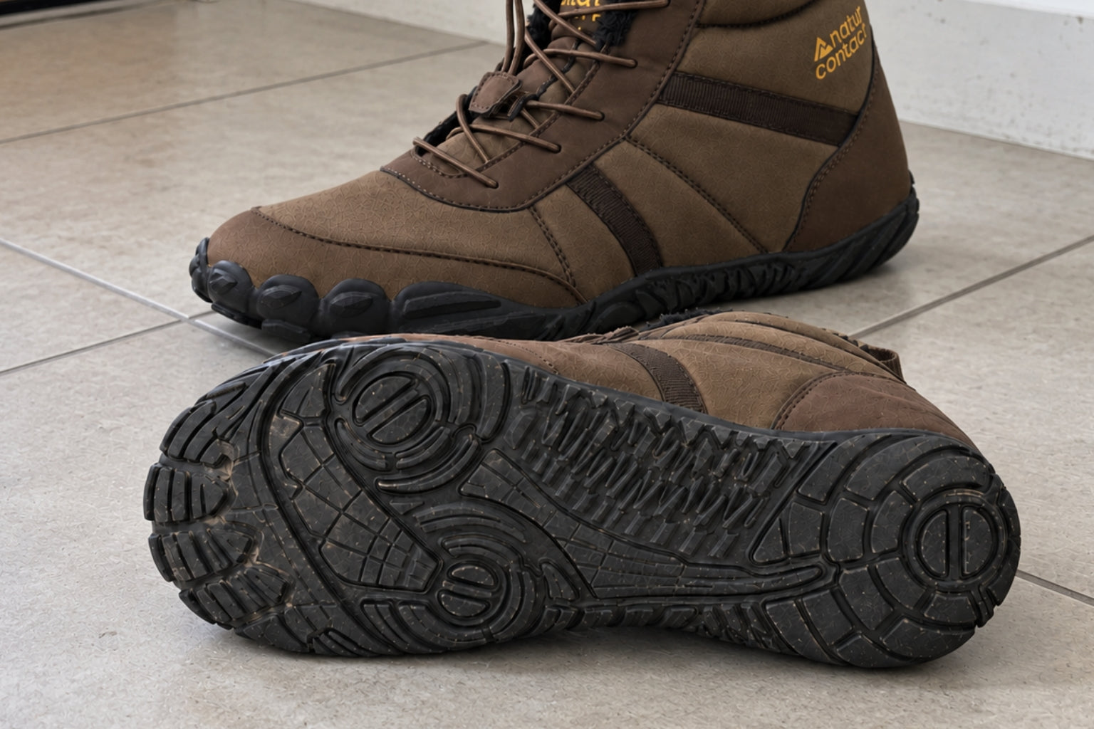 Brown Naturcontact Arctic Contact 4.0 barefoot boots on a tiled floor, with a close-up of the outsole tread.