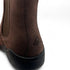 Close-up of a brown leather boot with a brand logo on a white background