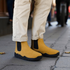 Sand barefoot chelsea boots with black soles worn on a sidewalk