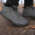 Gray winter boots with fur lining worn on a concrete surface.