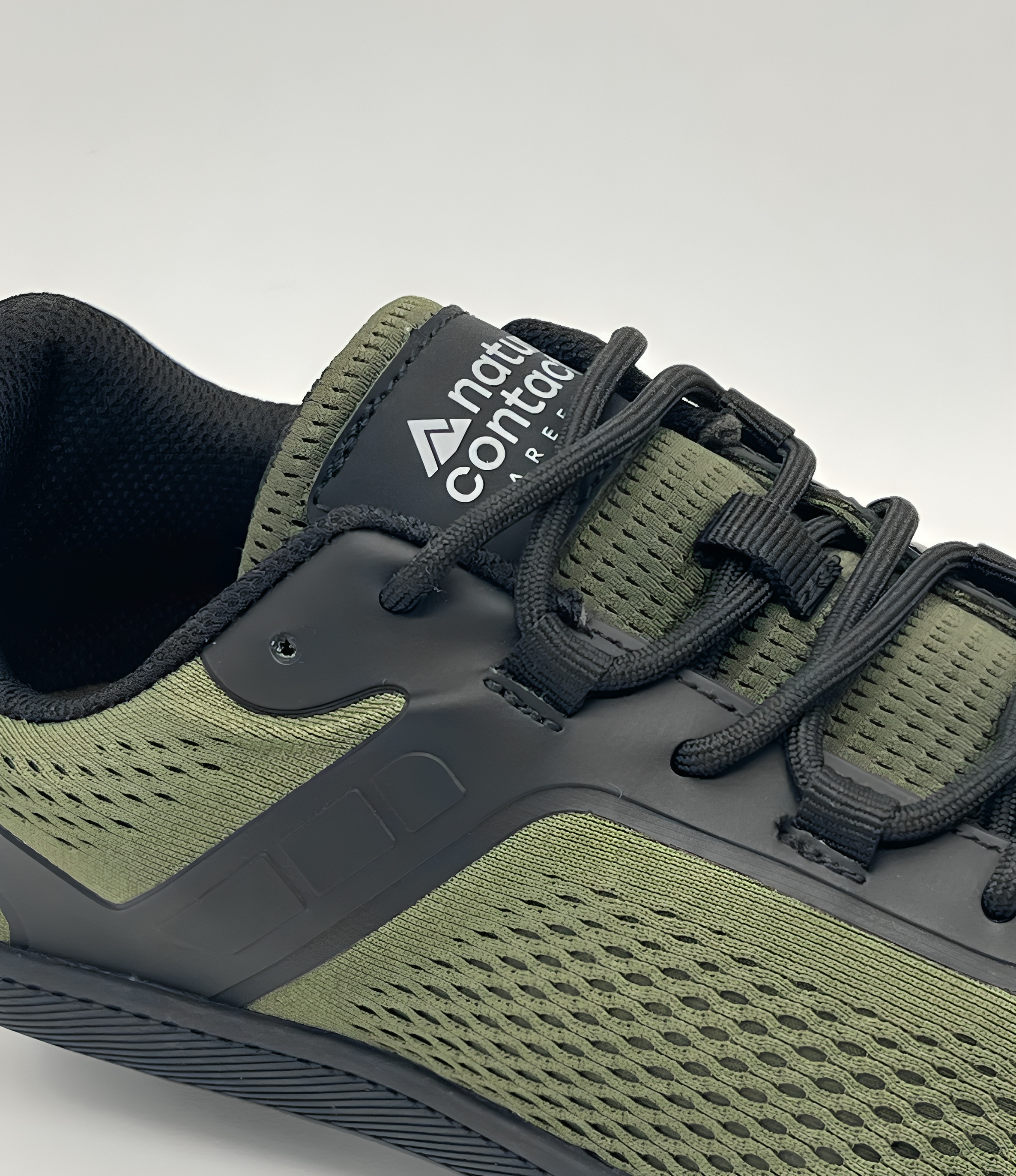 Green and gray athletic shoe with brand logo on a light gray background