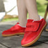 Red barefoot sneakers for kids with velcro straps on a wooden floor