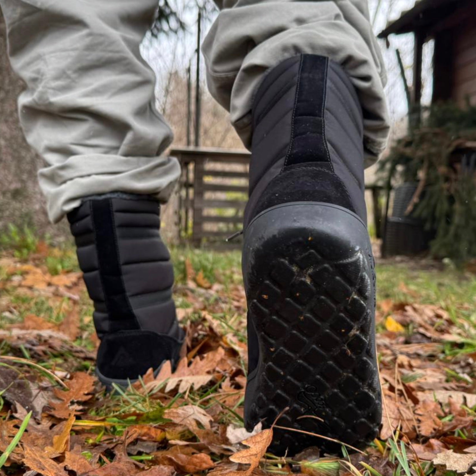 back view of high winter barefoot boots with sole detail in a mountain house with autumn leaves on the grass