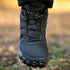 Black hiking boot with brand name on a blurred natural background