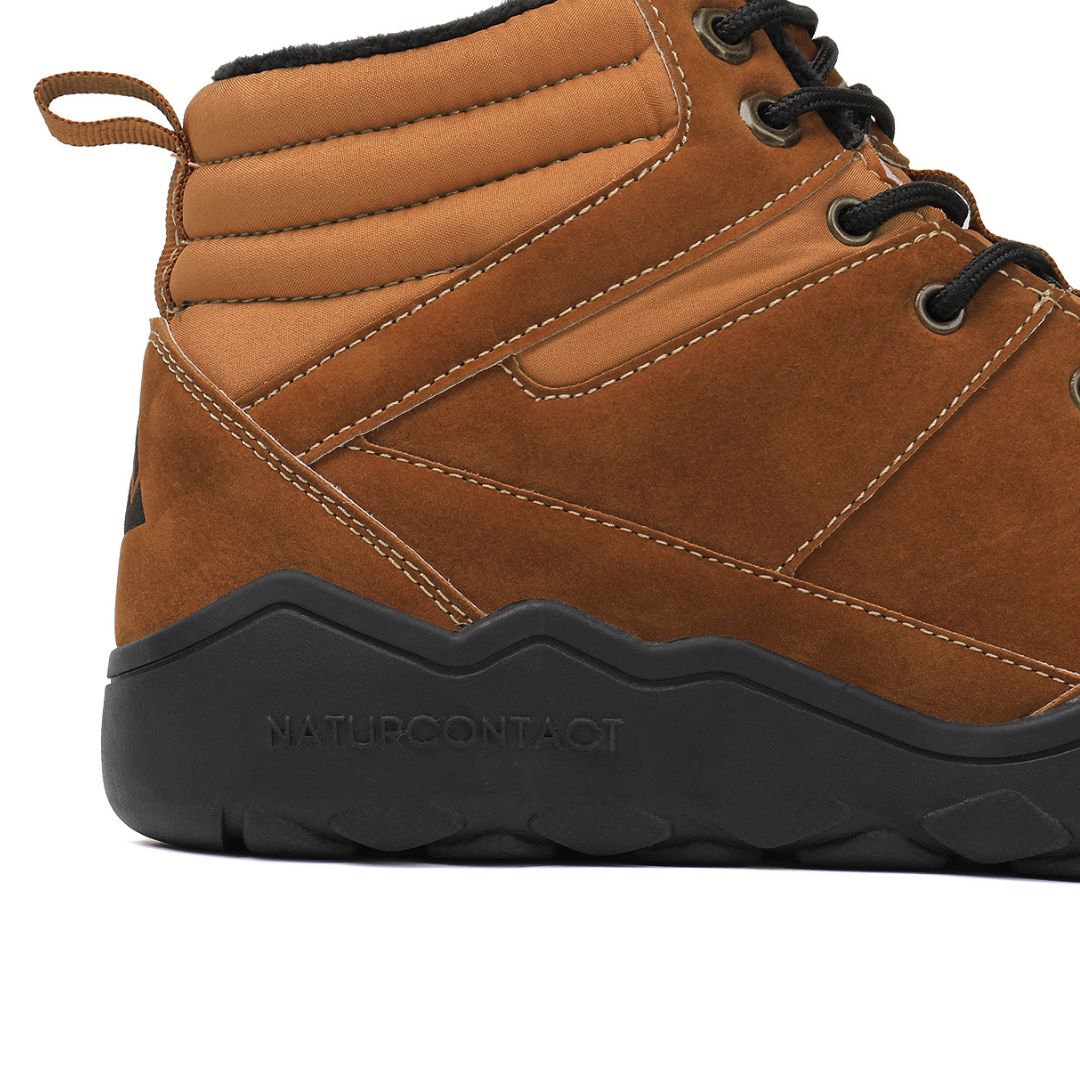 Gold winter barefoot shoe with black laces on a white background, close-up side view.
