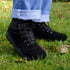 Black boots worn with rolled-up jeans on a grassy background